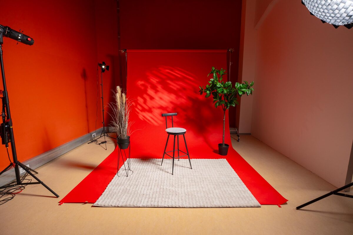 Roter Studio-Backdrop mit Hocker und Pflanzen im Roschkov-Media-Filmstudio