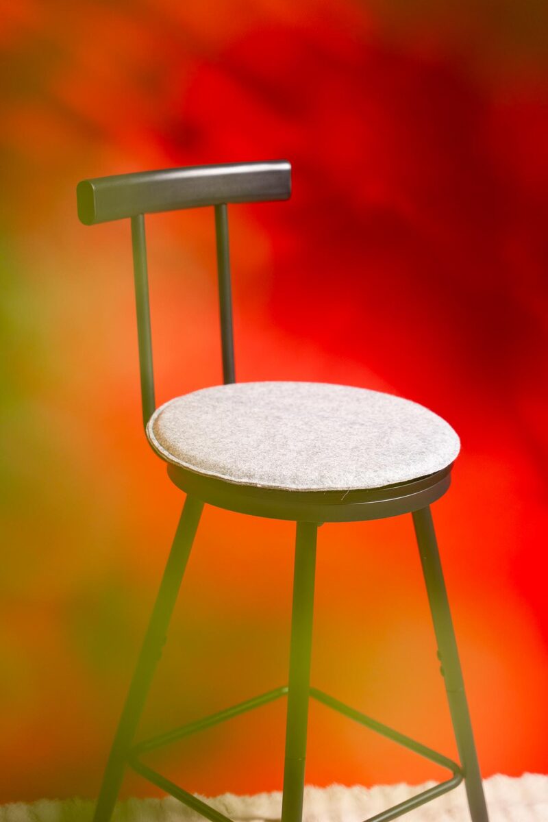 Hocker vor farbigem Licht-Hintergrund im Studio